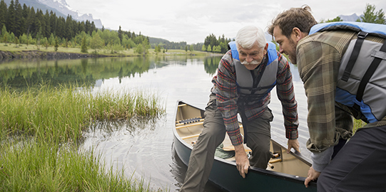 Son helping father out of canoe